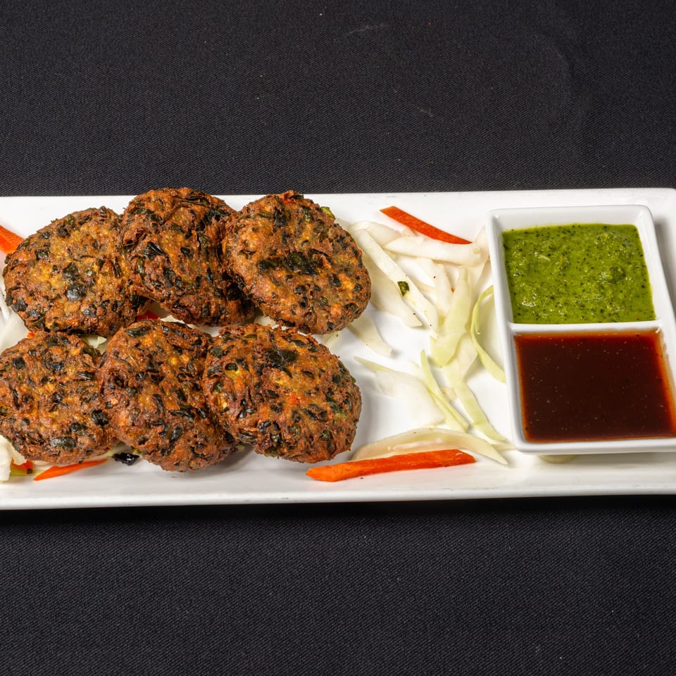Saffron Indian Cuisine's fried vegetable patties, served with green and brown dipping sauces.